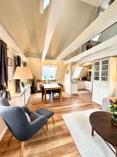 an open living room with a table and chairs at Deichhof Whg 26 in Dunsum