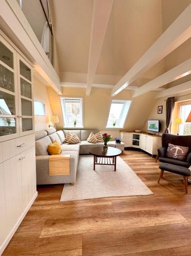 a living room with a couch and a table at Deichhof Whg 26 in Dunsum