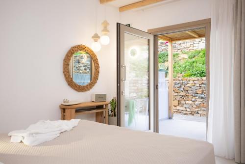 a bedroom with a bed and a sliding glass door at Miles Away Residences in Platis Gialos