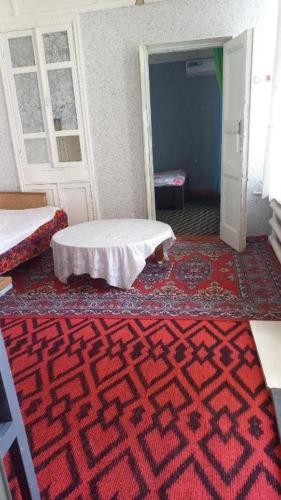 a room with a red carpet and a room with a table at Private Courtyard Cozy House in Tashkent