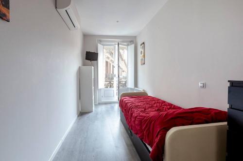 a white room with a bed and a refrigerator at Malasaña & Plaza España in Madrid
