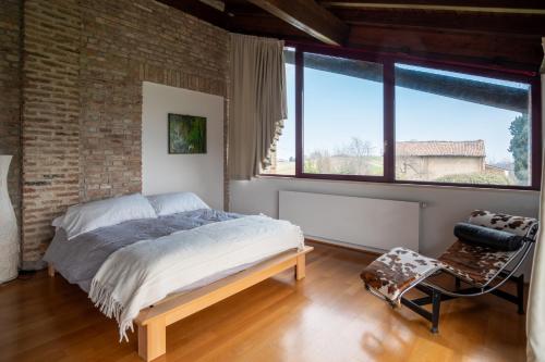 a bedroom with a bed and a brick wall at GuestHost - Casa delle Querce Villa with Pool in Gropparello