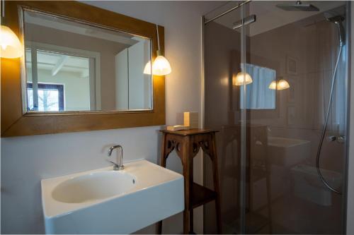 a bathroom with a sink and a mirror and a shower at GuestHost - Casa delle Querce Villa with Pool in Gropparello
