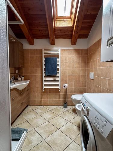 a bathroom with a toilet and a sink and a window at Appartamento Pommier in Saint-Pierre