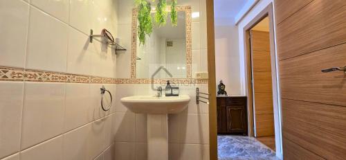 a bathroom with a sink and a mirror at La Casona y El Apartamento De La Foz in Lugar de Arriba
