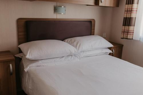 a bed with white sheets and pillows in a bedroom at Lower Cliff 19 in Easton