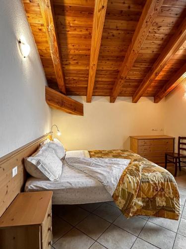 a bedroom with a bed with a wooden ceiling at Appartamento Pommier in Saint-Pierre