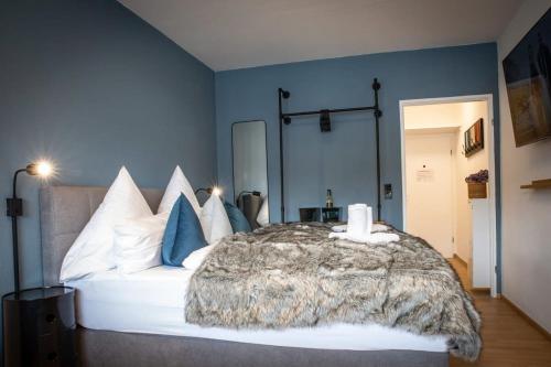 a bedroom with a large white bed with blue walls at Boutique-Apartment Südblick direkt im Zentrum in Oberstdorf