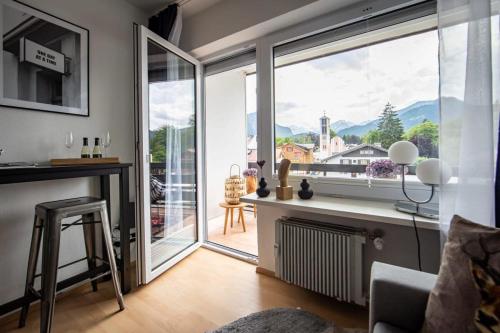 a living room with a large window with a view at Boutique-Apartment Südblick direkt im Zentrum in Oberstdorf