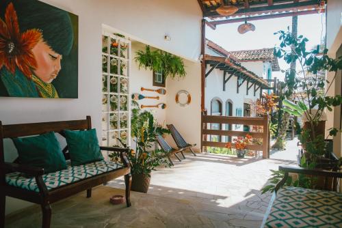 a patio with chairs and a painting on the wall at Casa Aldeia Paraty in Paraty