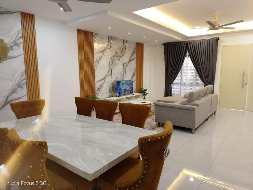 a living room with a table and chairs and a couch at HOMESTAY IMPIAN AYER MOLEK MUSLYM only in Malacca