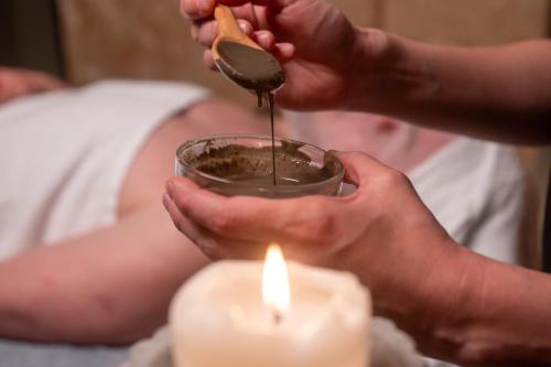 a person holding a cup with a spoon and a candle at Hotel Princesa Parc in Arinsal