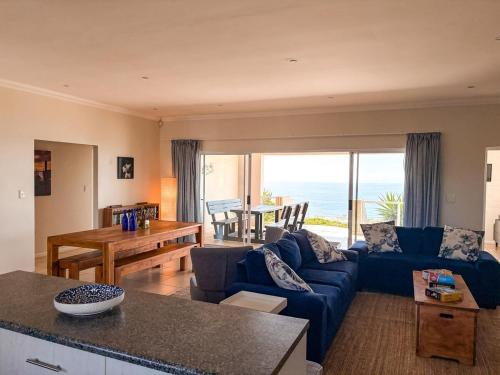 a living room with a blue couch and a table at On The Hill in Stompneusbaai
