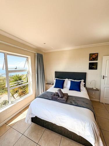 a bedroom with a large bed and a large window at On The Hill in Stompneusbaai