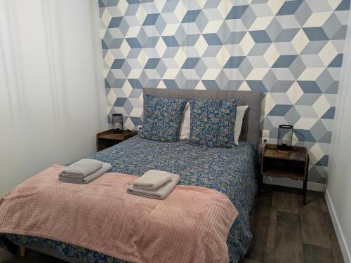 a bedroom with a bed with two towels on it at ANGEL Cozy duplex 2 chambres in Vitré
