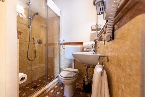 a bathroom with a shower and a toilet and a sink at Duomo Apartments Affittacamere in Cefalù