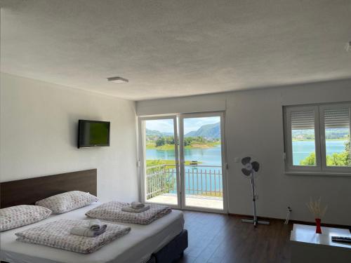 a bedroom with two beds and a view of a lake at Apartmani Mia in Prozor
