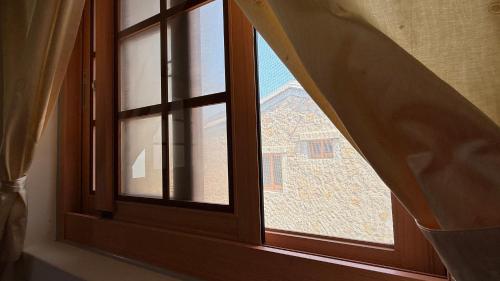 an open window with a view of a building at 芹壁山城民宿 Chinbe Hill Village House B&B in Beigan