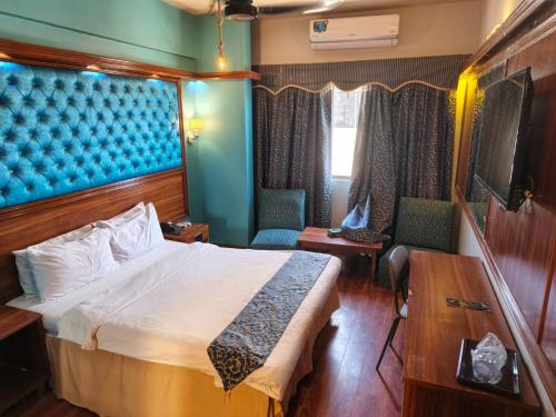 a hotel room with a bed and two chairs at Faran Hotel in Karachi