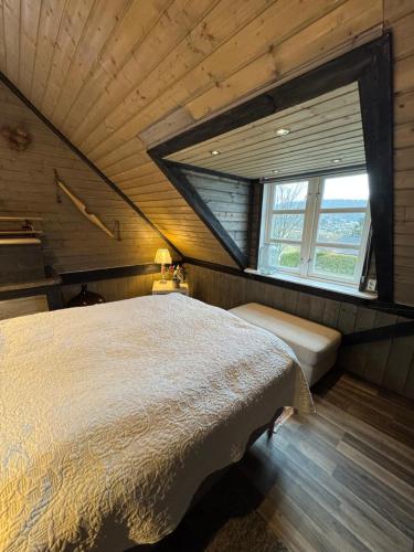 a bedroom with a large bed and a window at Eidsviklaaven in Ålesund