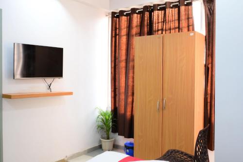 a living room with a tv and a cabinet at Hotel O Westin Regency in Monber