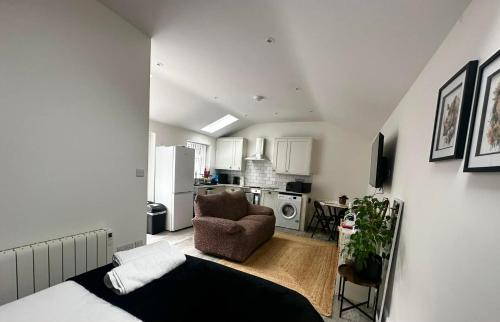 a living room with a couch and a kitchen at Brain Properties Limited - Garden flat with Parking near QA Hospital in Portsmouth