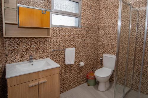 a bathroom with a toilet and a sink and a shower at Sunset Star II With Sea View in Calheta