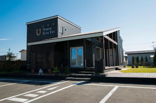 a black building with a sign on the side of it at North Gate Inn ABIRA in Chitose