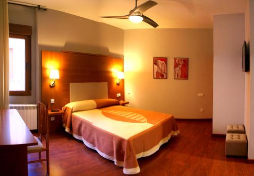 a hotel room with a bed and a ceiling fan at hotel rural ATALAYA in Alcañices