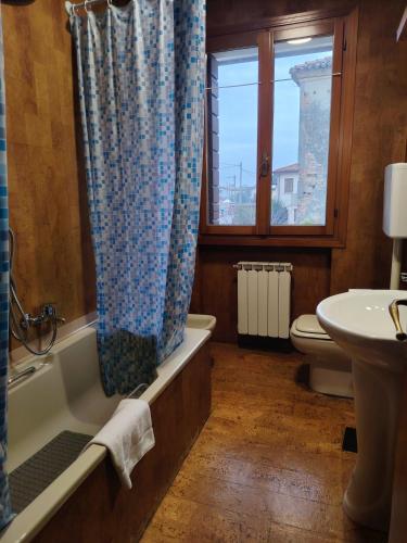 a bathroom with a tub and a toilet and a sink at 3 double bedrooms in Aloisia Home - near Venice Airport in Tessera