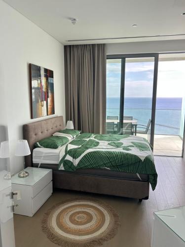 a bedroom with a bed and a view of the ocean at Trilogy Limassol East Tower Seafront Apartment in Limassol