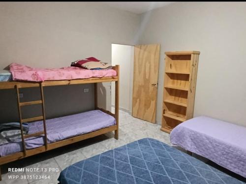 a room with two bunk beds and a door at Los Horneros Zamba in Cerrillos