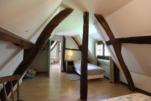 a bedroom with a bed with wooden beams at La Chaumière aux Faisans in Ablon