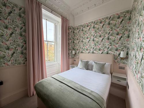 una camera da letto con un letto e una finestra di Sonas Guesthouse a Edimburgo