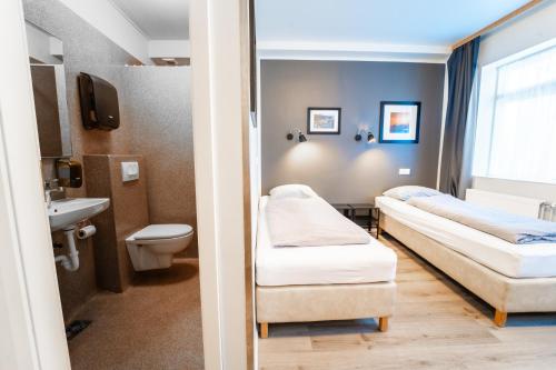 a hospital room with two beds and a sink at Guesthouse Aurora in Reykjavík