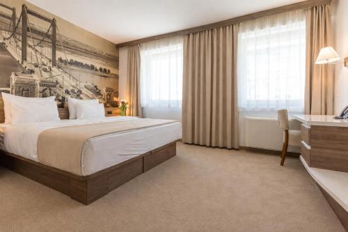a hotel room with a large bed and a desk at Hotel Royal Inn in Belgrade