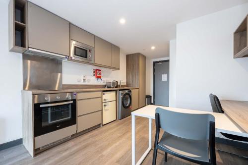 a kitchen with a table and a dining room at Studios For 2 Near Coventry Station in Coventry