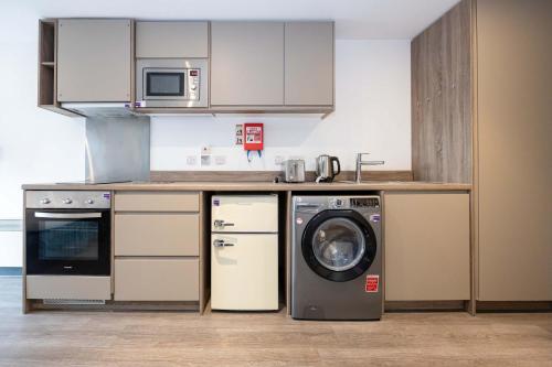 a kitchen with a washer and a dishwasher in it at Studios For 2 Near Coventry Station in Coventry