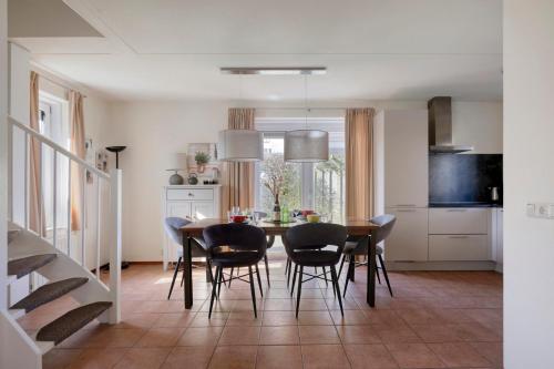 a kitchen and dining room with a table and chairs at Holidayhouse Banjaard in Kamperland