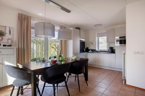 a kitchen and dining room with a table and chairs at Holidayhouse Banjaard in Kamperland
