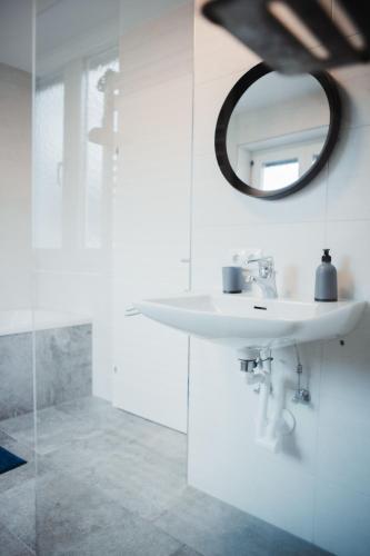 a white bathroom with a sink and a mirror at Haus Edelweiss in Tarrenz