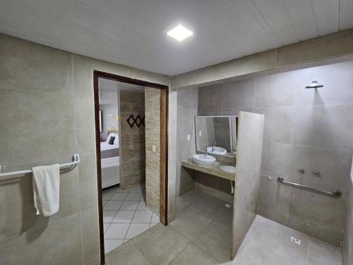 a bathroom with a sink and a toilet and a mirror at Pousada Maraoka in Porto De Galinhas