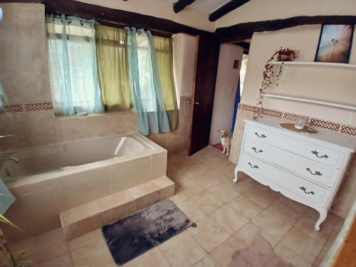 a bathroom with a tub and a white dresser at The Witch's Cottage in Urubamba