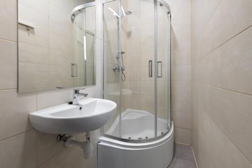 a bathroom with a sink and a glass shower at Rooms Nearto Main Square in Krakow
