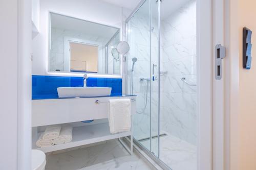 a bathroom with a sink and a shower at Orbi City Collection in Batumi