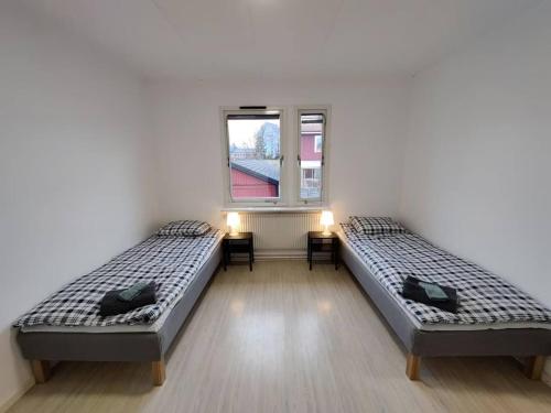 two beds sitting in a room with a window at Workers Stay - Temporary House Gothenburg in Gothenburg