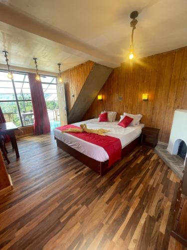 a bedroom with a large bed in a room with wooden floors at Redwood inn homestay in Nuwara Eliya