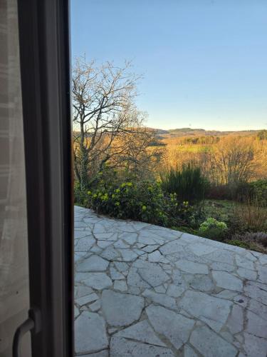 a view from a window of a stone walkway at Edelweiss in Moux-en-Morvan