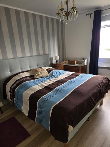 a bedroom with a large bed with a striped wall at Edelweiss in Moux-en-Morvan