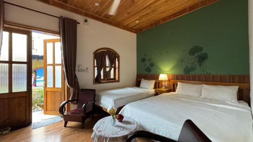a hotel room with two beds and a chair at Hoàng Doji de Villa in Thôn Dương Xuân Hạ